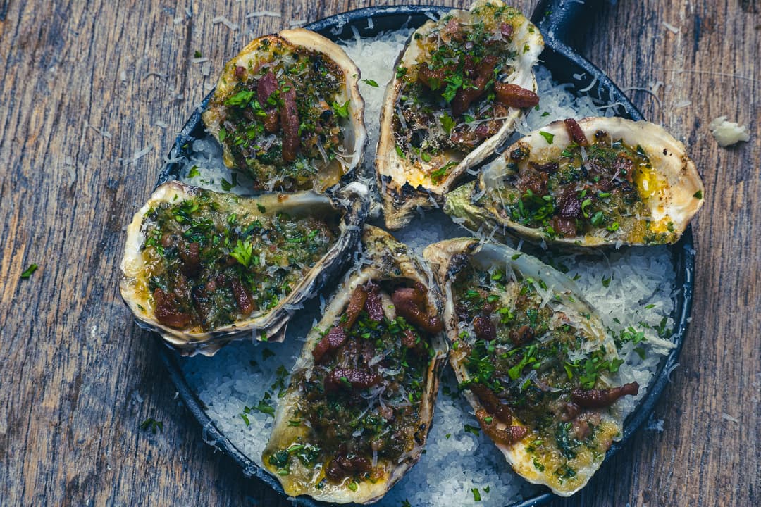 Flambierte Austern mit ausgebratenem Speck und Parmesankäse